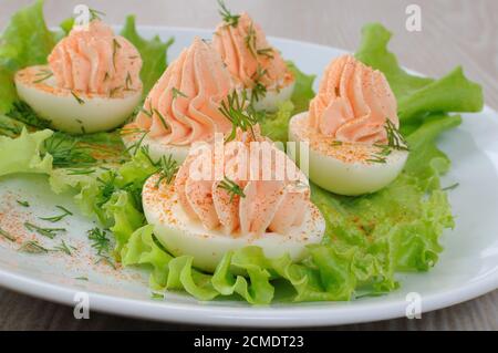 Uova ripiene di pâté di salmone in foglie di lattuga Foto Stock