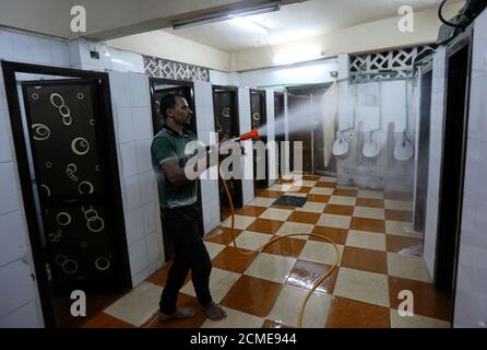 Un volontario spray disinfettante in bagni all'interno di una moschea come è preparato per la preghiera dopo essere stato riaperto, a seguito dello scoppio della malattia del coronavirus (COVID-19), al Cairo, Egitto, 26 giugno 2020. REUTERS/Mohamed Abd El Ghany