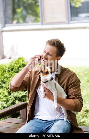 Uomo in abiti bianchi con un gadget in mano Foto stock - Alamy