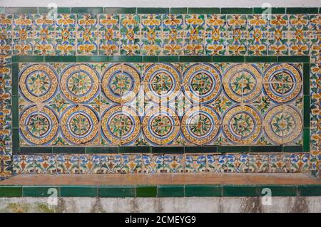 Parete con piastrelle in ceramica che decorano il retro di una panchina nell'Alcazar di Siviglia, Spagna Foto Stock