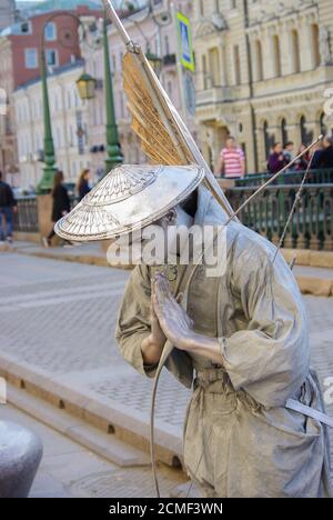 Performer - artisti dipinti in argento su una strada della città, statue viventi Foto Stock