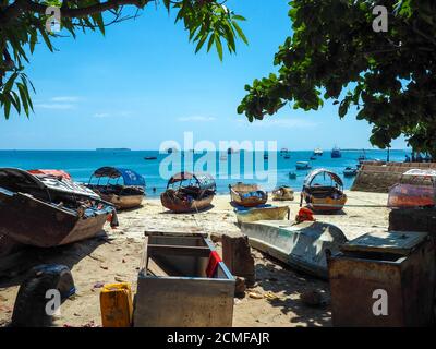 Barche da pesca e acque turchesi cristalline nella città di pietra sull'isola di zanzibar. Foto Stock