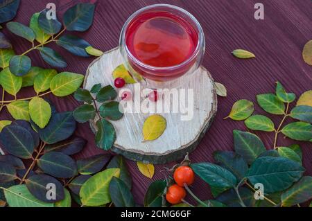 Tè alla frutta con frutti di bosco viburnum su una superficie di legno Foto Stock