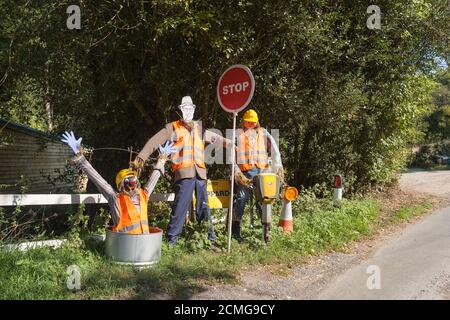 Vista insolita a grandezza naturale sulla corsia di campagna vestita 3 falco da lavoro in piedi che indossa un'uniforme intelligente nel giardino di fronte con stop segno e una sorpresa Foto Stock