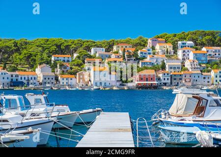 Città di Lussinpiccolo sull'isola di Lussino, costa adriatica in Croazia, barche su banchine e vecchie case in background Foto Stock