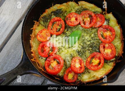 Pizza al formaggio in padella di ghisa con pomodori freschi Foto Stock