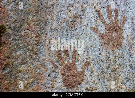 Stampe a mano umane dipinte sulla superficie in pietra Foto Stock