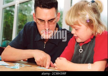 Padre che aiuta la figlia con abilità di alfabetizzazione Foto Stock