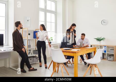 I giovani si incontrano in un ambiente di lavoro accogliente e moderno e ne discutono progetti aziendali Foto Stock