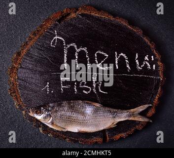 Pesci secchi carp su un di legno nero albero di taglio Foto Stock