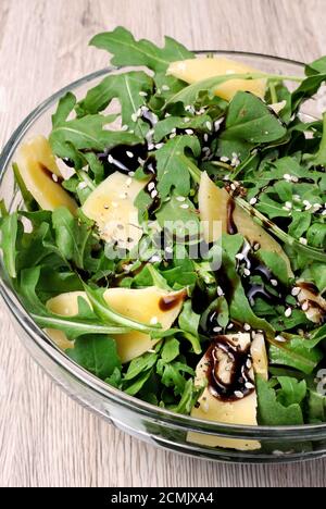 Insalata di rucola condita con salsa di soia balsamica, scaglie di parmigiano e nero macinato fresco Foto Stock