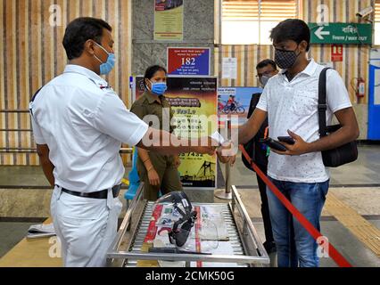 Kolkata, India. 17 Settembre 2020. Un uomo che indossa un facemask è sottoposto a screening termico presso una stazione della metropolitana di Kolkata da un ufficiale di polizia per mantenere le linee guida Covid-19 per le stazioni della metropolitana.poiché il blocco del coronavirus è sollevato a Kolkata, le stazioni della metropolitana sono esortate a rispettare le linee guida COVID-19 per garantire che la malattia non si diffonda ulteriormente. Credit: SOPA Images Limited/Alamy Live News Foto Stock