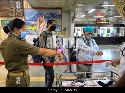 Kolkata, India. 17 Settembre 2020. Un ufficiale di polizia che indossa un facemask istruisce i passeggeri a mostrare le loro mani per il controllo della temperatura corporea.mentre il lockdown del coronavirus è sollevato a Kolkata, le stazioni della metropolitana sono esortate a rispettare le linee guida COVID-19 per garantire che la malattia non si diffonda ulteriormente. Credit: SOPA Images Limited/Alamy Live News Foto Stock