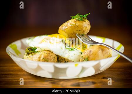 patate bollite con uova fritte e aneto Foto Stock