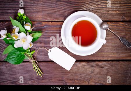 Il tè nero in un bianco coppa rotonda con un piattino Foto Stock