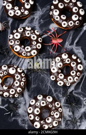 Ciambelle con glassa di cioccolato decorato occhi d'oca su Halloween Foto Stock
