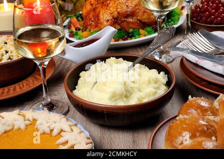 Una ciotola di purè di patate su un tavolo tra la torta di zucca, tacchino al forno, salsa di mirtillo-arancio, Foto Stock