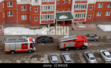 Motore antincendio nel cortile di un edificio residenziale a più piani in inverno. Foto Stock