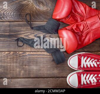 Coppia di rosso sneakers tessili e di cuoio rosso guantoni da pugilato Foto Stock