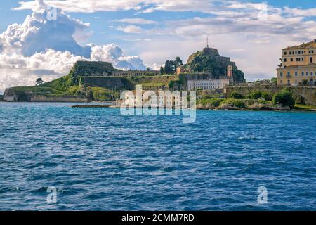 Isola di Corfù/Grecia - 7 maggio 2019: Paesaggio urbano di Kerkyra - baia di mare con acque turchesi calme, antica fortezza veneziana in pietra, vecchie case storiche, Foto Stock