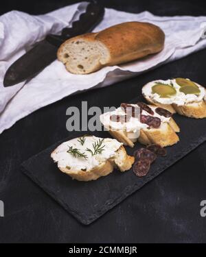 Sandwich con crema di formaggio bianco, salsiccia, olive e aneto Foto Stock