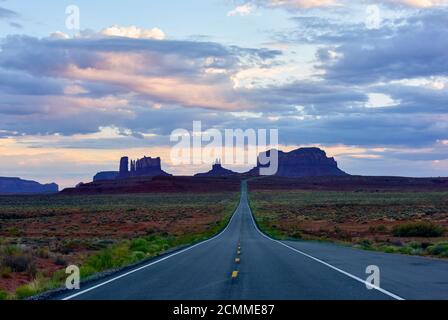 Paesaggio desertico della Monument Valley Arizona / Utah con una prospettiva svanente dell'autostrada in un paesaggio lontano. Foto Stock