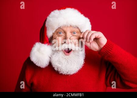 Che sconti x-mas. Scioccato anziano pensionato uomo in babbo natale cappello sguardo incredibile vacanza novo anno notizie toccare occhiali occhiali indossare luminoso Foto Stock