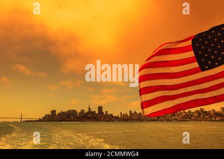 Bandiera americana con paesaggio urbano della Baia di San Francisco. Cielo arancione fumoso per incendi californiani negli Stati Uniti d'America. Composizione. Foto Stock