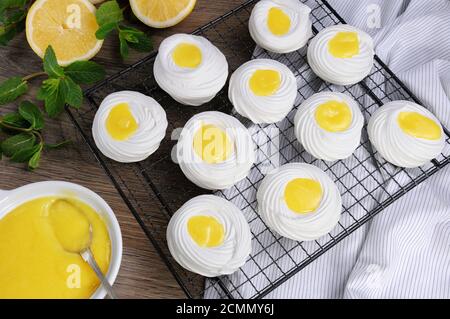 Ripieno con un curd al limone, un mini-dessert delicato e croccante Pavlova sulla griglia Foto Stock