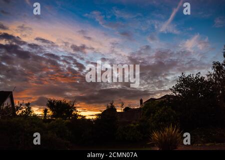 The setting sun over East Budleigh village in Devon. Foto Stock
