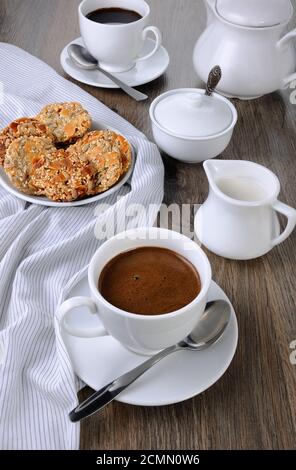 Una tazza di caffè con senza glutine cookies da cereali sul tavolo da caffè. Si tratta di tempo hanno un morso Foto Stock