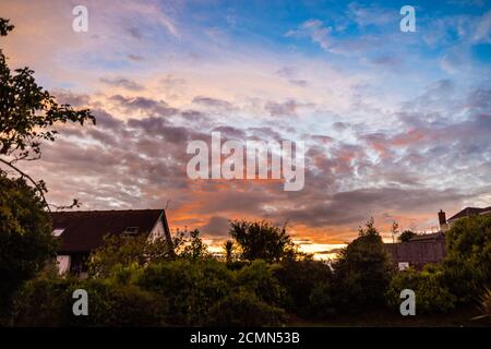 Il sole che tramonta sul villaggio di East Budleigh nel Devon. Foto Stock