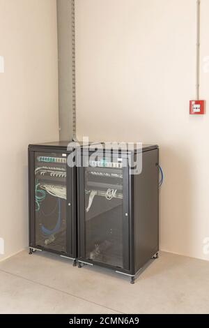 Due contenitori per rack per server e cabinet di rete in camera Foto Stock