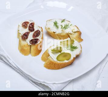 Sandwich con crema di formaggio bianco, salsiccia, olive e aneto Foto Stock