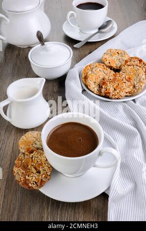 Una tazza di caffè con senza glutine cookies da cereali sul tavolo da caffè. Si tratta di tempo hanno un morso Foto Stock