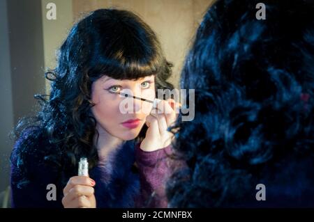 Giovane donna che applica mascara. Prepararsi per il gioco. Heritage Park Scuola secondaria, Mission, BC, Canada Foto Stock
