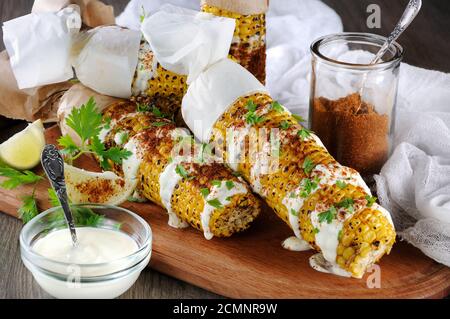 Delizioso mais fritto, grattugiato con lime, versato con salsa e condito con spezie speziate. Indiana e. Foto Stock