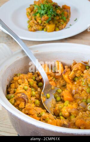 Carota e lenticchie al curry in ciotola con cucchiaio Foto Stock