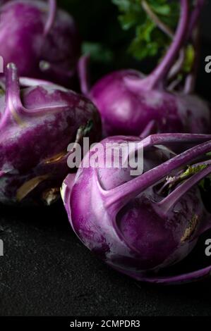 Kohlrabi viola. Scatto su sfondo nero in un tasto basso. Foto Stock