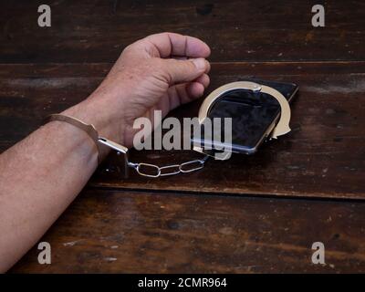 Un uomo ammanettato per uno smartphone. Smartphone o internet addiction concept Foto Stock