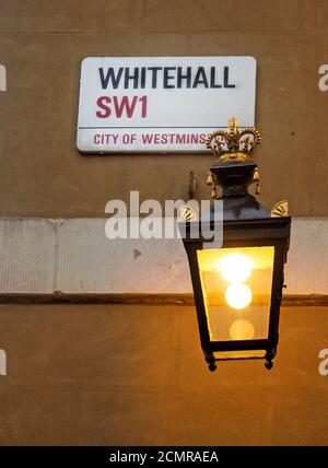 Whitehall targa nome con una vecchia lanterna a candela illuminata. La strada è riconosciuta come il centro del governo del Regno Unito Foto Stock