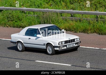 BMW 325I bianca anni '1986 80; veicoli in movimento per traffico veicolare, auto che guidano veicoli sulle strade del Regno Unito, motori, motori sulla rete autostradale M6. Foto Stock