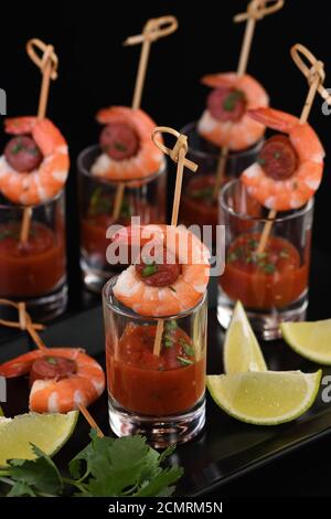 Antipasto di shish kebab con gamberi e chorizo ​​sausages con salsa barbecue in un bicchiere Foto Stock