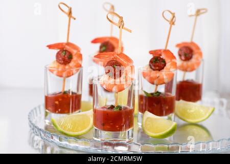 Antipasto di shish kebab con gamberi e chorizo salsicce con salsa barbecue in un bicchiere Foto Stock