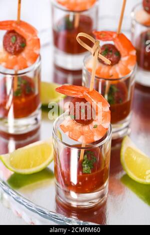 Antipasto di shish kebab con gamberi e chorizo salsicce con salsa barbecue in un bicchiere Foto Stock