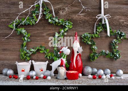 Composizione natalizia con gnomi, figurine di alci e decorazioni festive su sfondo ligneo. Biglietto d'auguri per Natale o Capodanno. Foto Stock