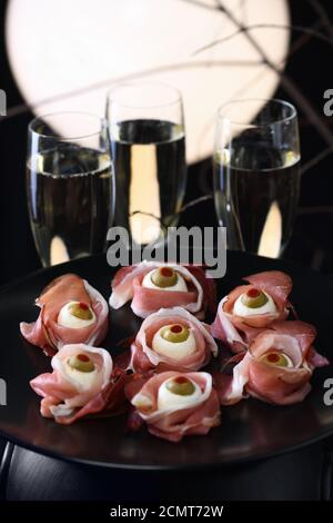 Spuntini originali di Halloween. Bulbi cotti da jamon con mozzarella, olive farcite con peperone rosso Foto Stock