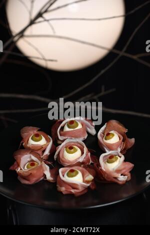 Spuntini originali di Halloween. Bulbi cotti da jamon con mozzarella, olive farcite con peperone rosso Foto Stock