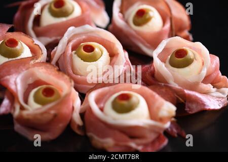 Spuntini originali di Halloween. Bulbi cotti da jamon con mozzarella, olive farcite con peperone rosso Foto Stock