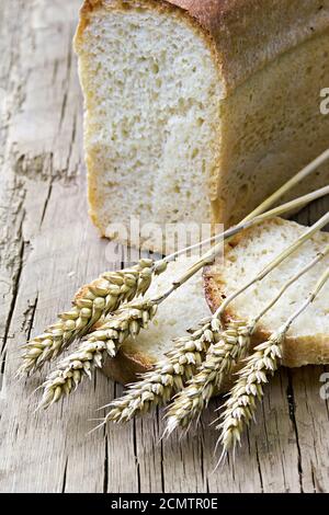 pane di pane e spighe di grano sullo sfondo Foto Stock